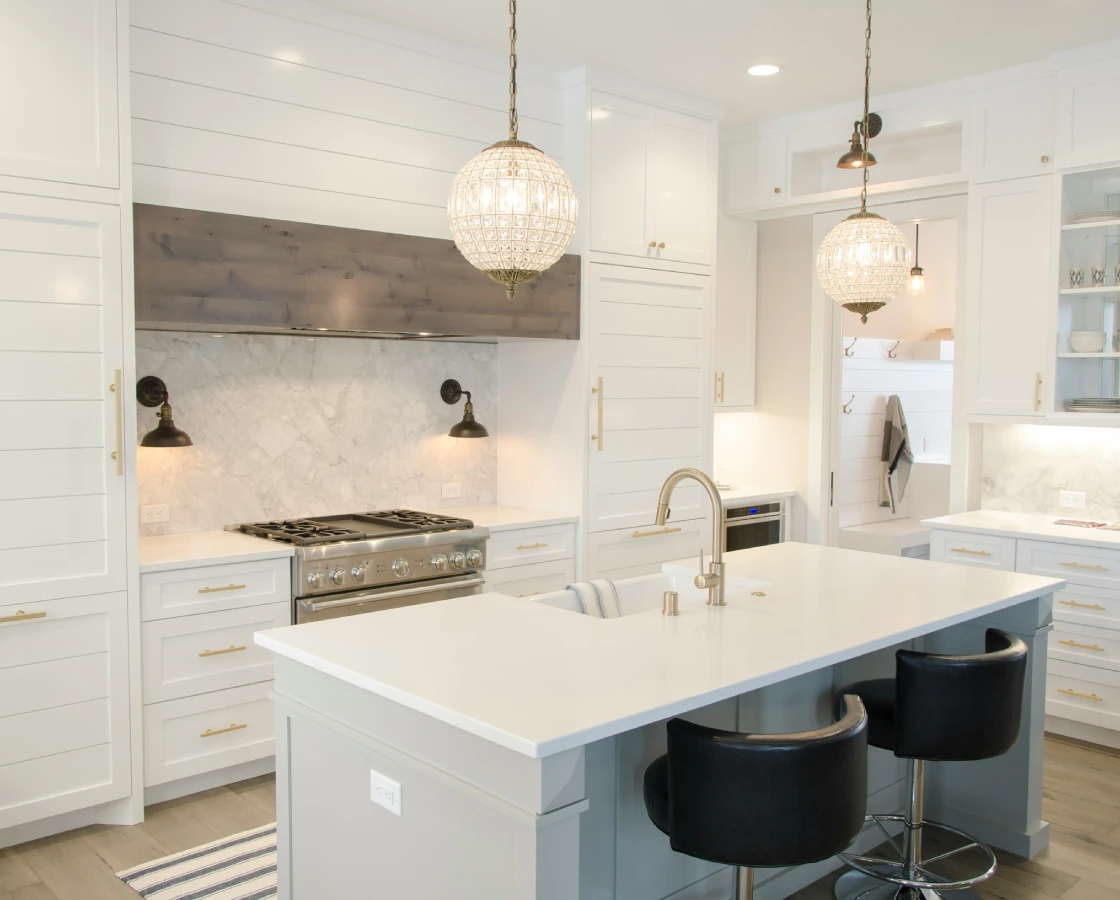 Modern white kitchen island with black stools